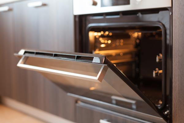 Open oven representing heat and energy similar to early universe conditions used to ask how old is the universe.