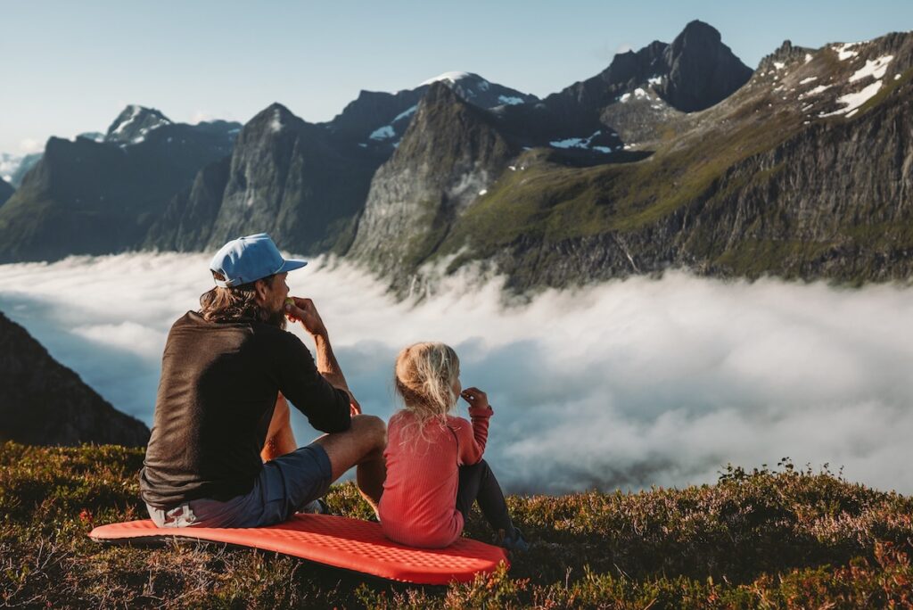 A man and a little girl resting from their mountain hike, representing God's rest in the seventh day of creation.