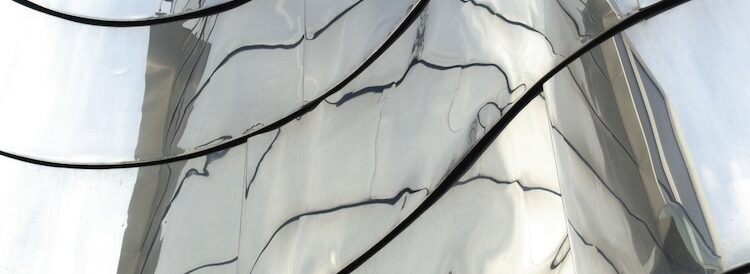 Close-up of rippled, reflective metal panels with dark curved seams, forming distorted reflections that evoke how sin has marred the image of God in humanity.