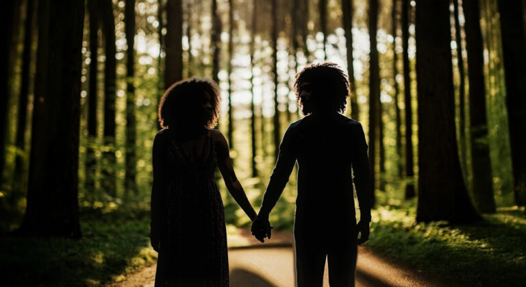 Silhouetted couple holding hands on a forest path, reflecting ideas about what did Adam and Eve look like.