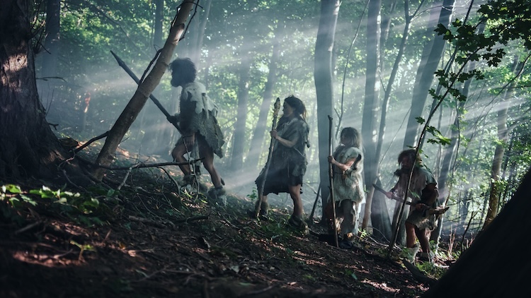Early humans trekking through a dense forest with spears and primitive clothing, illustrating human migration across prehistoric landscapes.