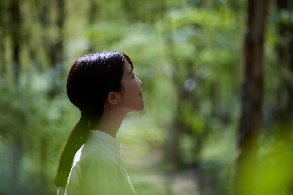 A woman walking through a forest, enjoying God's creation.