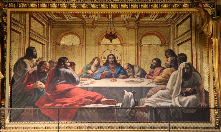 A detailed depiction of the Last Supper shows Jesus at the center of a long table with his disciples. The setting is a grand room with arched windows.