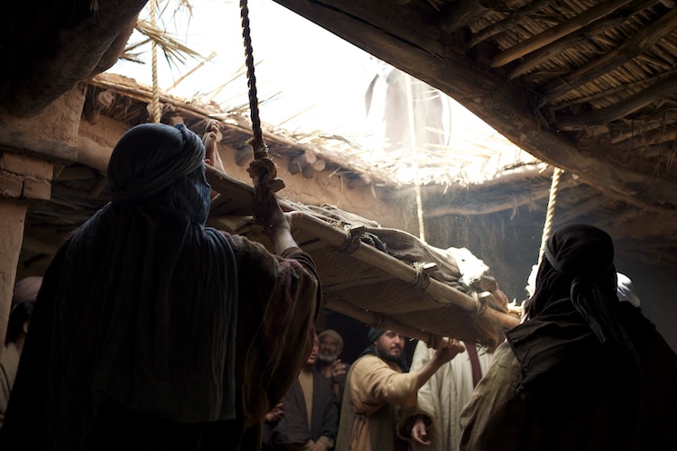 A paralyzed man is lowered through the roof of a house so he can be healed by Jesus.