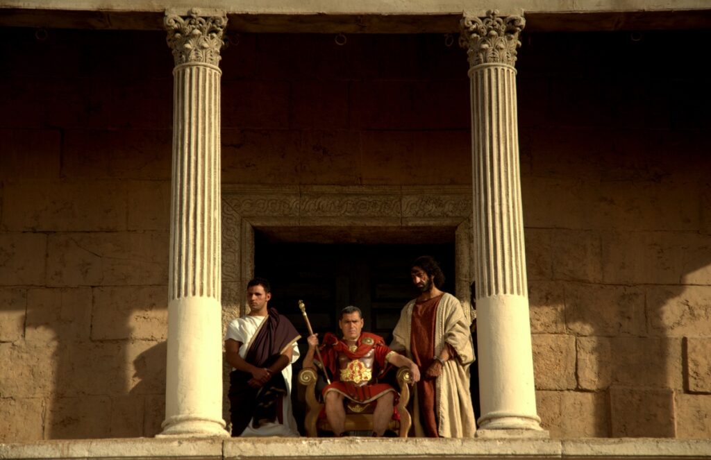 Pilate holds court at the praetorium, questioning Jesus who stands before him.