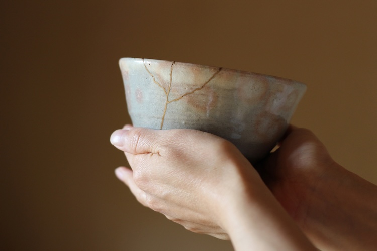 Hands holding a repaired, mended bowl, symbolizing how Jesus restores and makes us whole.
