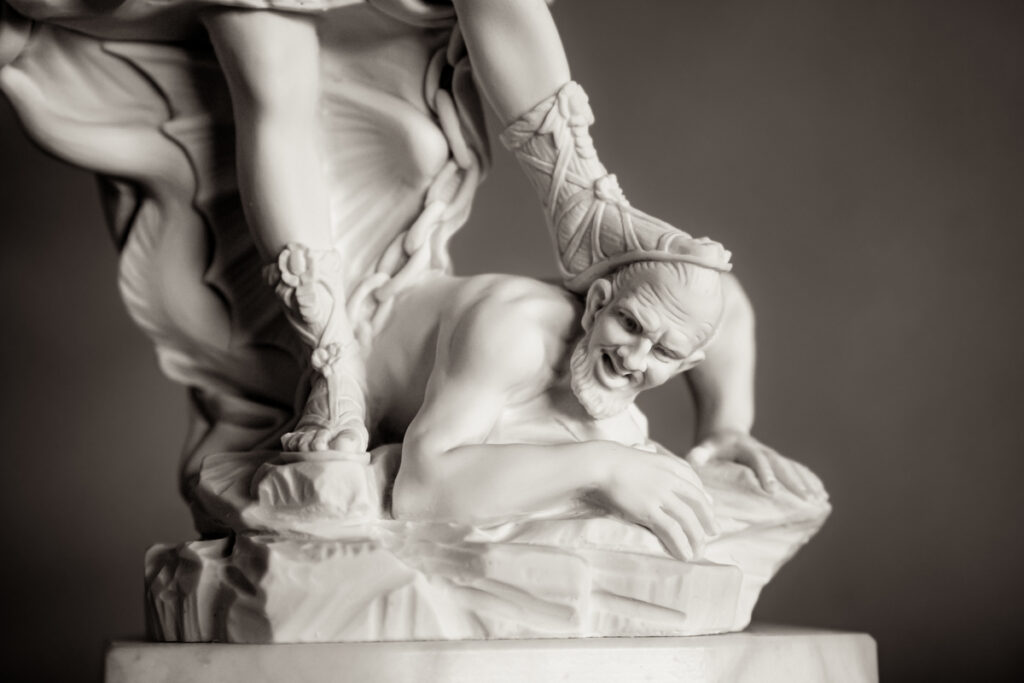 A marble statue depicting Satan being crushed under Jesus' foot.