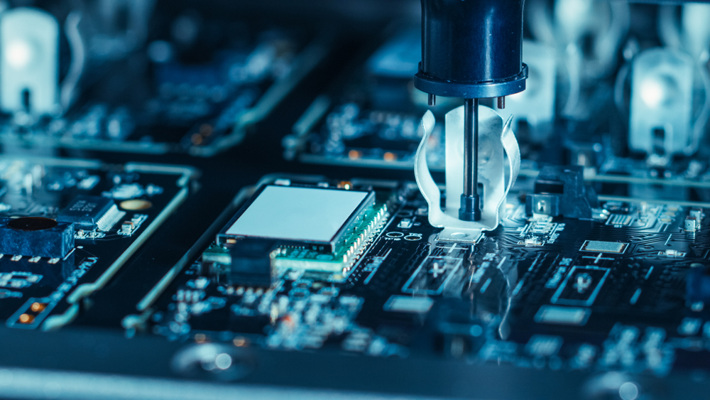 Robot-assisted hardware operating on a circuit board, representing discussions around the ethics of artificial intelligence.