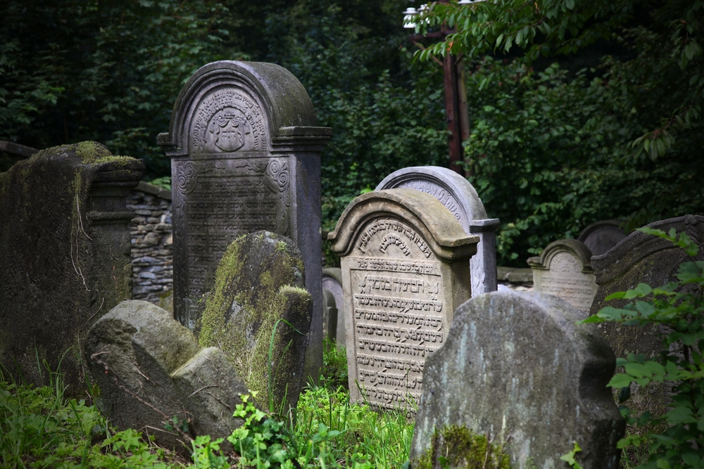Old cemetery gravestones representing the human question of life after death.