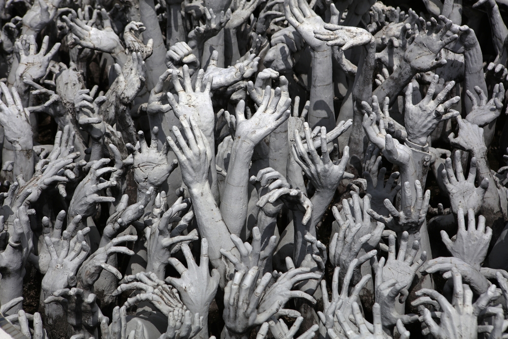 A sea of arms upraised with decaying hands clawing upward, reminiscent of sensational horror depictions of demon possession and exorcisms.
