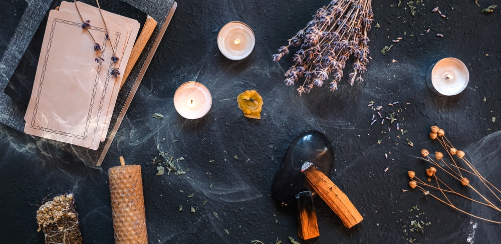 Spiritual altar for occult practices with oracle cards, candles, herbs, and other items that open doors to demon possession.