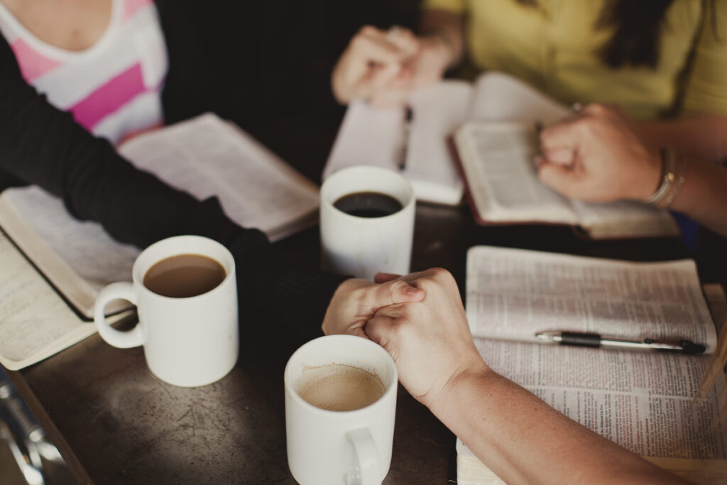 Small group Bible study with women discussing Scripture and faith in Christianity.