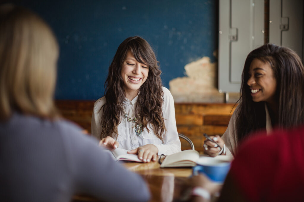 Group of women studying together and discussing faith, illustrating the role of women in Christianity.