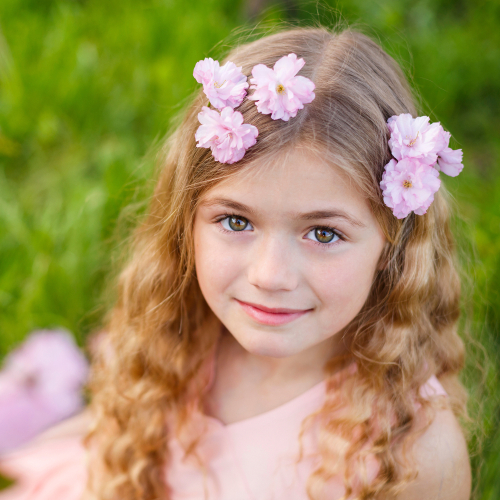 A young girl with flowers in her hair is pictured next to an image of a chimpanzee, illustrating a comparison often used in discussions about human origins and human evolution.