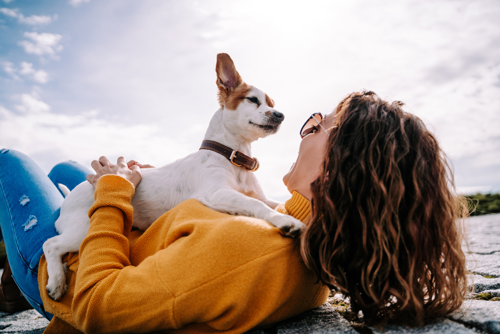 A dog owner enjoying her dog