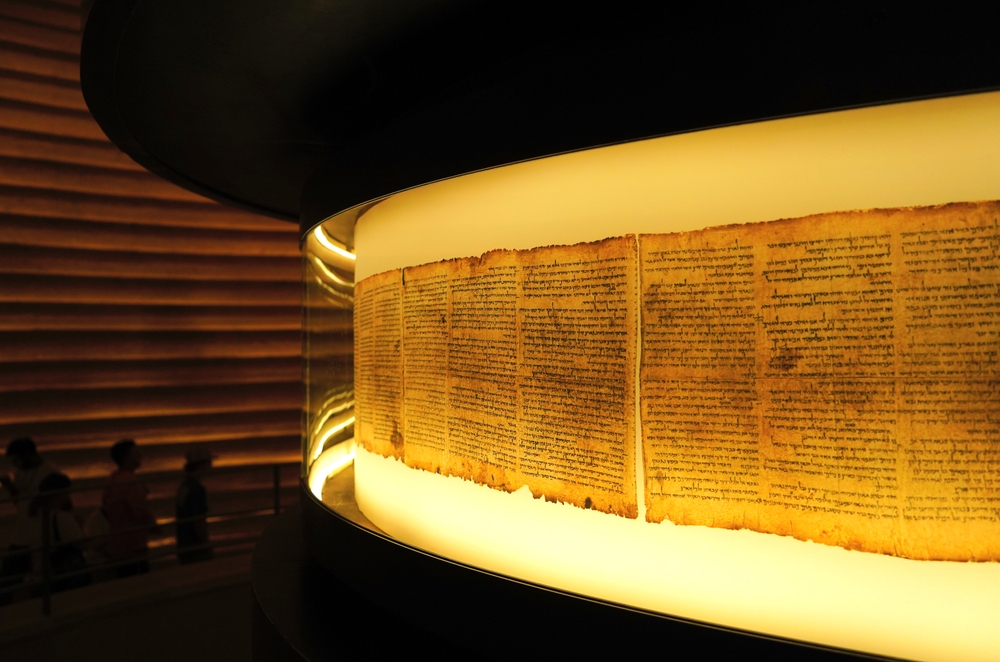 An ancient manuscript displayed under soft lighting in a circular case.