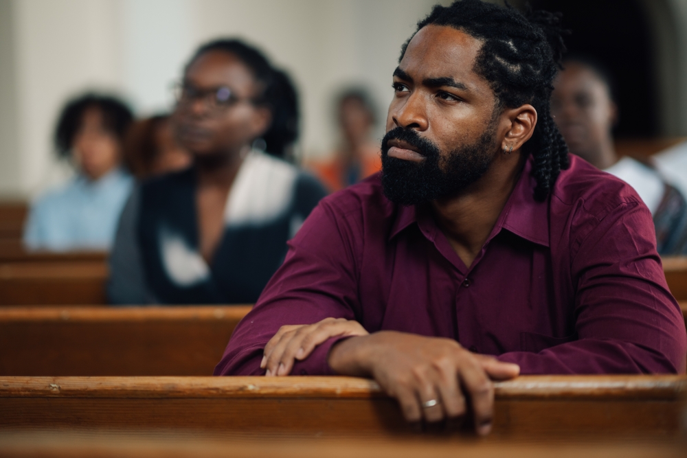 Churchgoers listen to a sermon—an example of how faith is expressed and lived out through Christian religious practices.